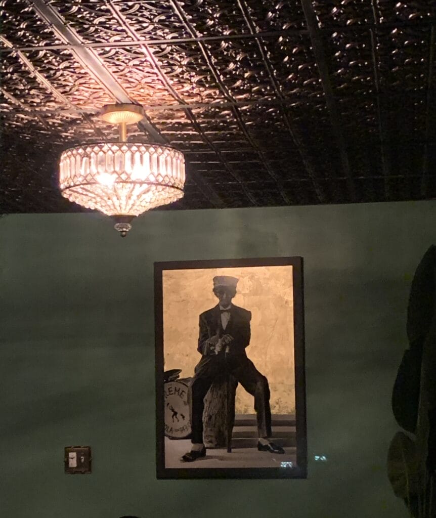 Interior shot with beautiful old school ceiling, lights and a painting of a jazz musician on the wall