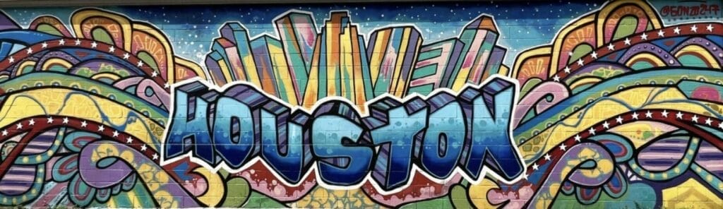 Graffiti art in Houston. Painted wall with colorful 'Houston" and high rise backdrop on the wall.