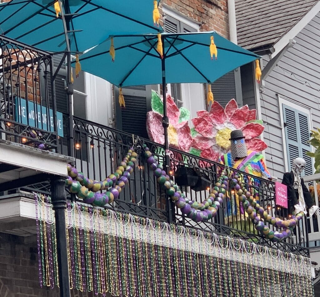 Colorful balcony with mardi gras colorful beads and flowers in N'awlins.