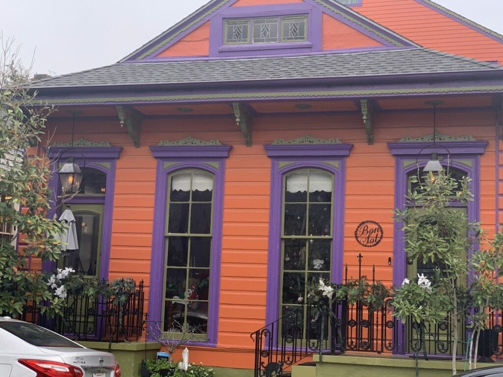 Vibrant and colorful homes lining the streets of New Orleans, showcasing a kaleidoscope of hues and tones. Bright walls with dark purple really stands out.