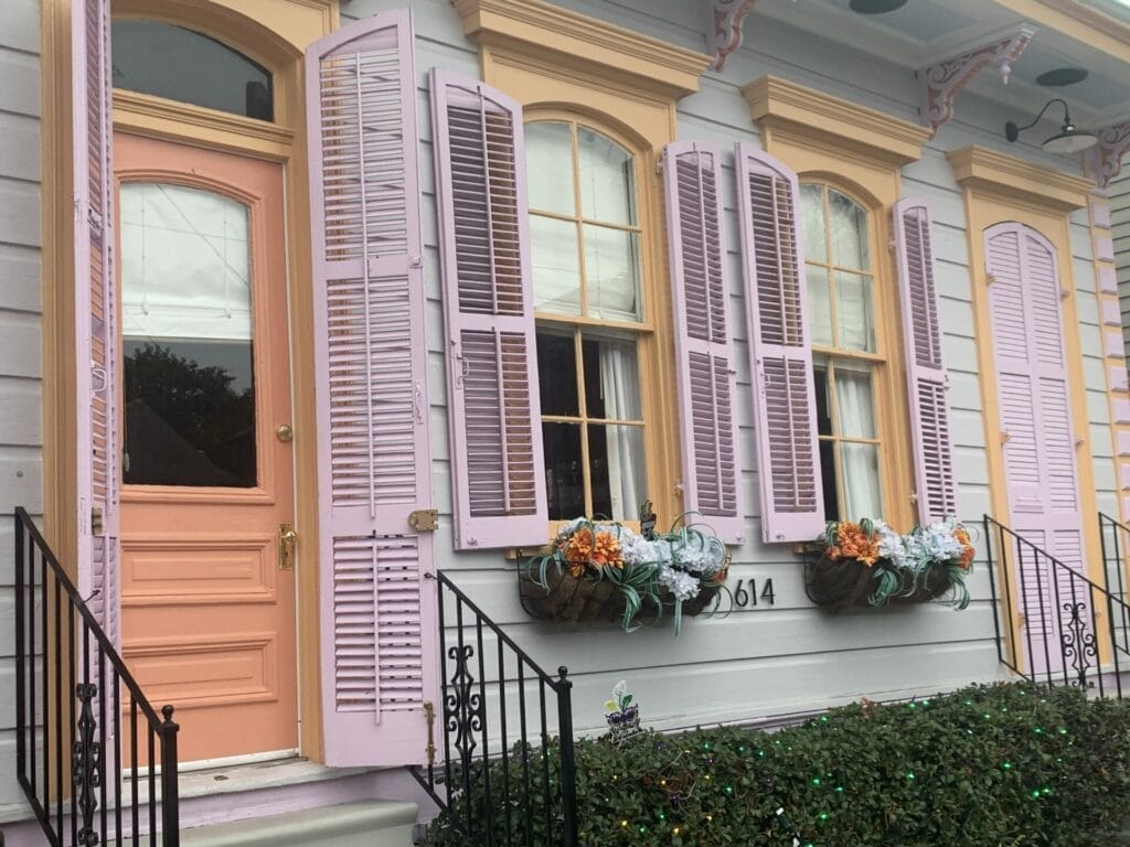 Vibrant and colorful homes lining the streets of New Orleans, showcasing a kaleidoscope of hues and tones. A house with peach, violet and cream colors.