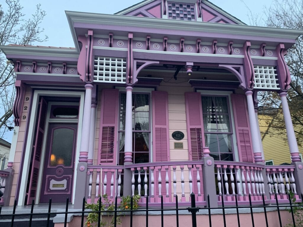 Vibrant and colorful homes lining the streets of New Orleans, showcasing a kaleidoscope of hues and tones. Purple and pink combination house.