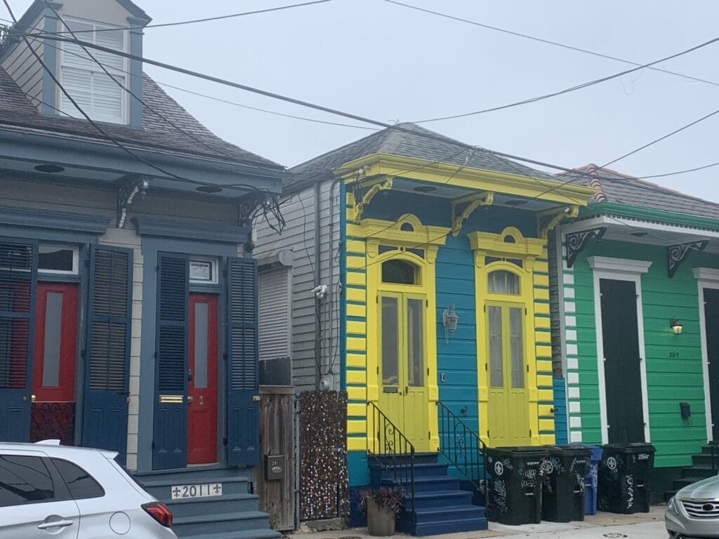 Vibrant and colorful homes lining the streets of New Orleans, showcasing a kaleidoscope of hues and tones. Bright yellow colorful home.