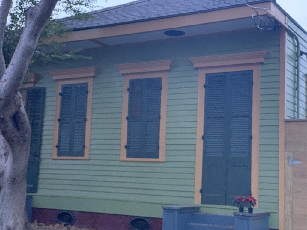 Vibrant and colorful homes lining the streets of New Orleans, showcasing a kaleidoscope of hues and tones. Soft colors with shutters closed.