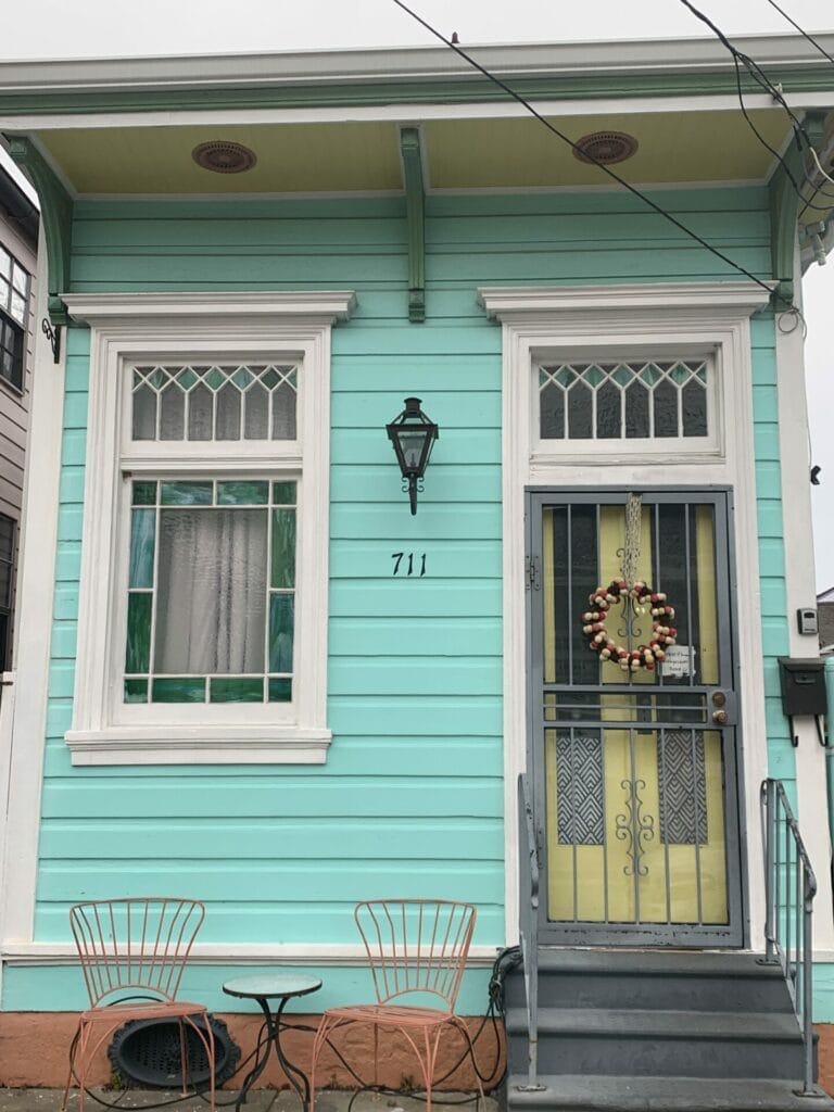 Vibrant and colorful homes lining the streets of New Orleans, showcasing a kaleidoscope of hues and tones. Teal with cream frams.