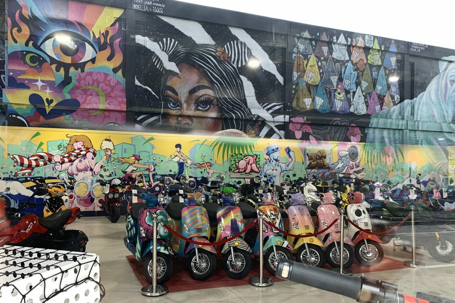 Vibrant street mural in Wynwood, Florida, showcasing colorful artwork on urban walls. Skooters everywhere...even have them painted!