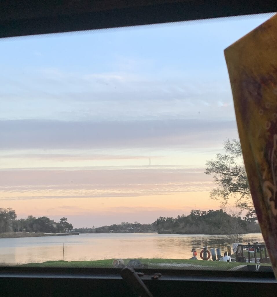 Sunset colors in the sky reflecting on the water, viewed from inside our van through the side window.