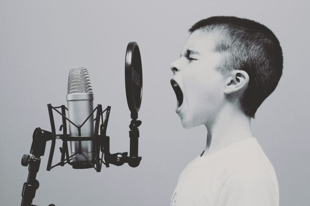 boy singing on microphone with pop filter demostrating muscle shoals sound.