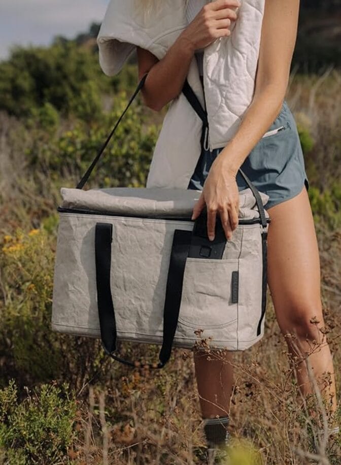 lady wearing shorts carrying an eco-friendly cooler out in the nature.