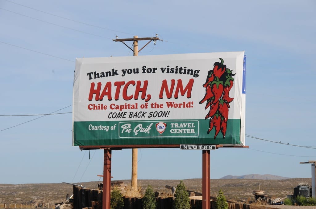 A sign on the side of the road that reads "Thank you for visiting Hatch, NM, Chile capital of the World. Come Back Soon!"