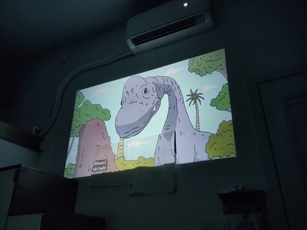 Purple dragon is shown as a cartoon from the projector on the wall.