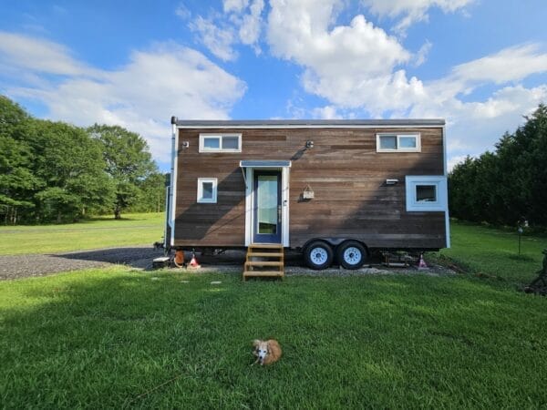 Tiny wooden house on beautiful green lawn with blue sky.