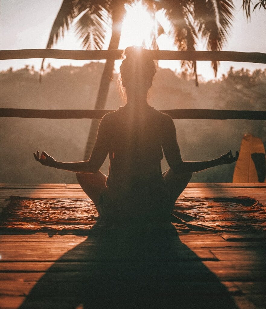 woman doing mindfulness meditation on wooden porch.