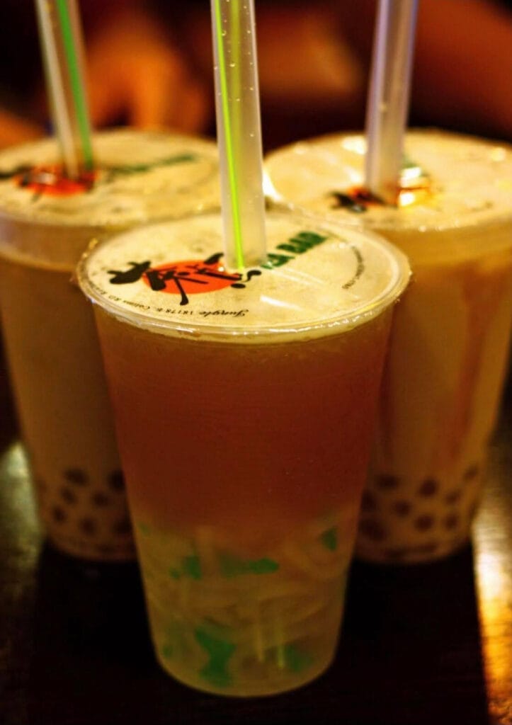 3 cups of boba drinks with cups sealed and fat boba poked in.