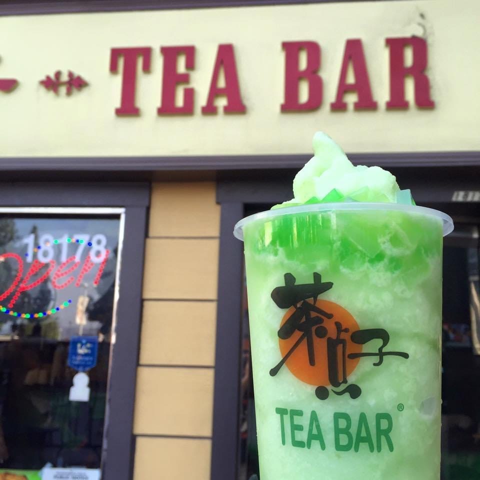 Tea Bar drink that's apple green with green jelly in front of Tea Bar shop.