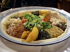 Vegetable platter with various vegetables and grains and salad is gorgeously placed on the plate.