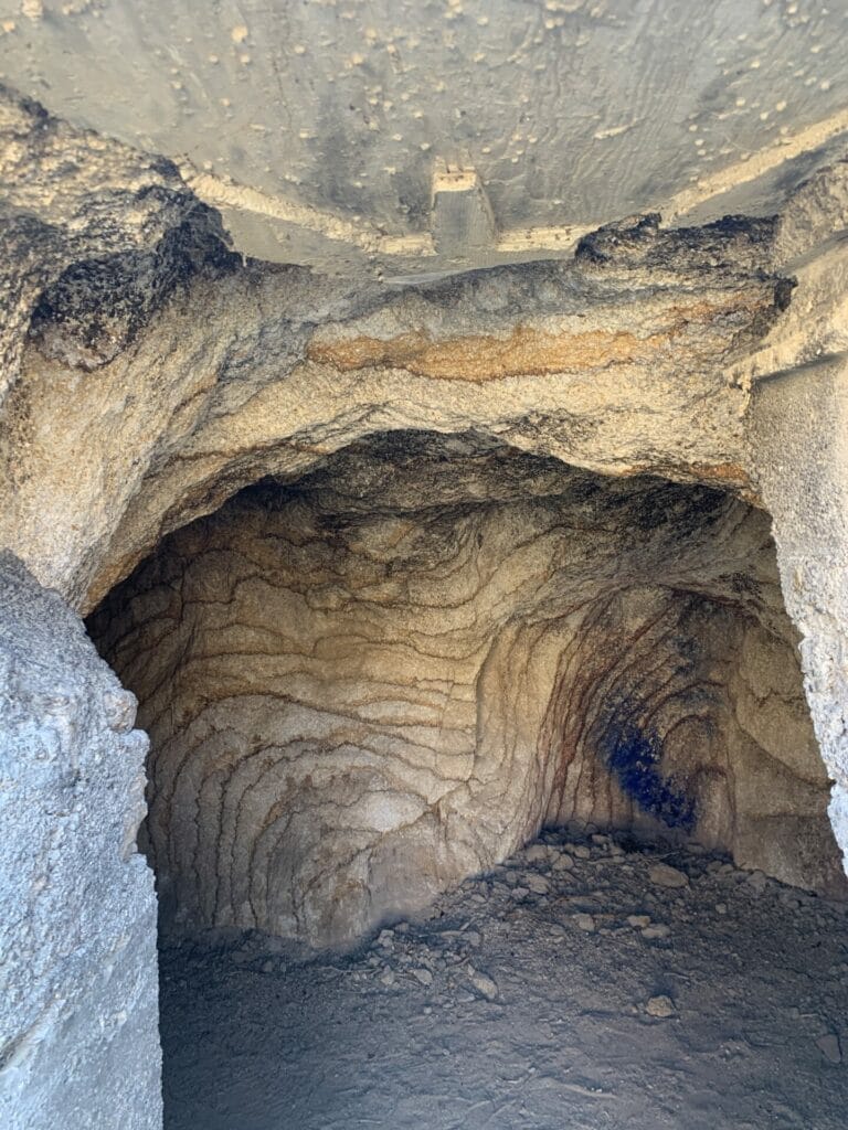 Inside a cave with curved interior and beautiful lines on the walls showcasing the beauty and mystics of nature.