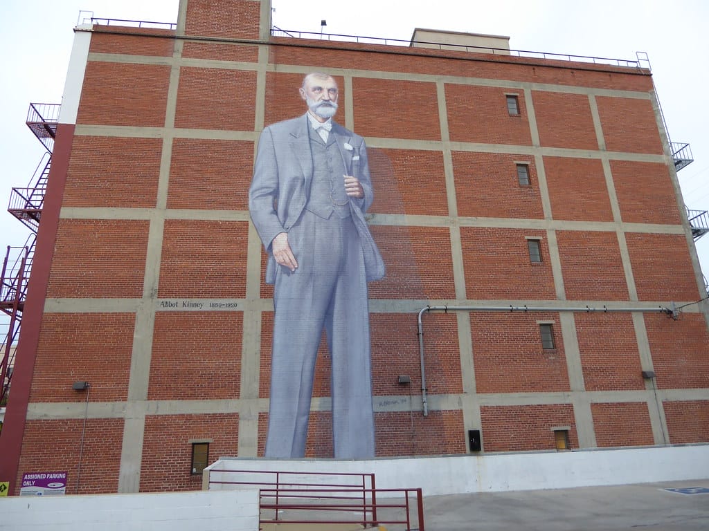 Huge mural of Abbot Kinney on the side of a 5 story brick building in Venice Beach. One who dug the Venice Beach Canal.