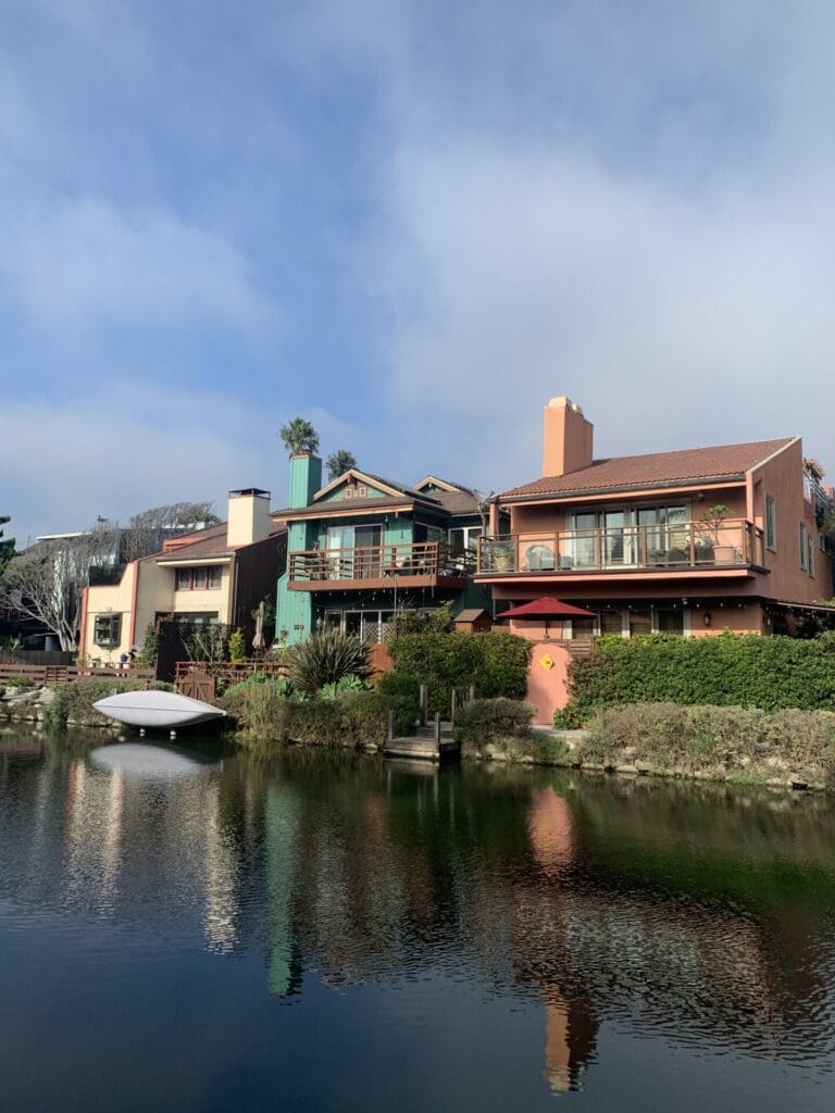 Charming homes on the bank of waterway with boats docked. Photo captured during sunset showing an orange glow.