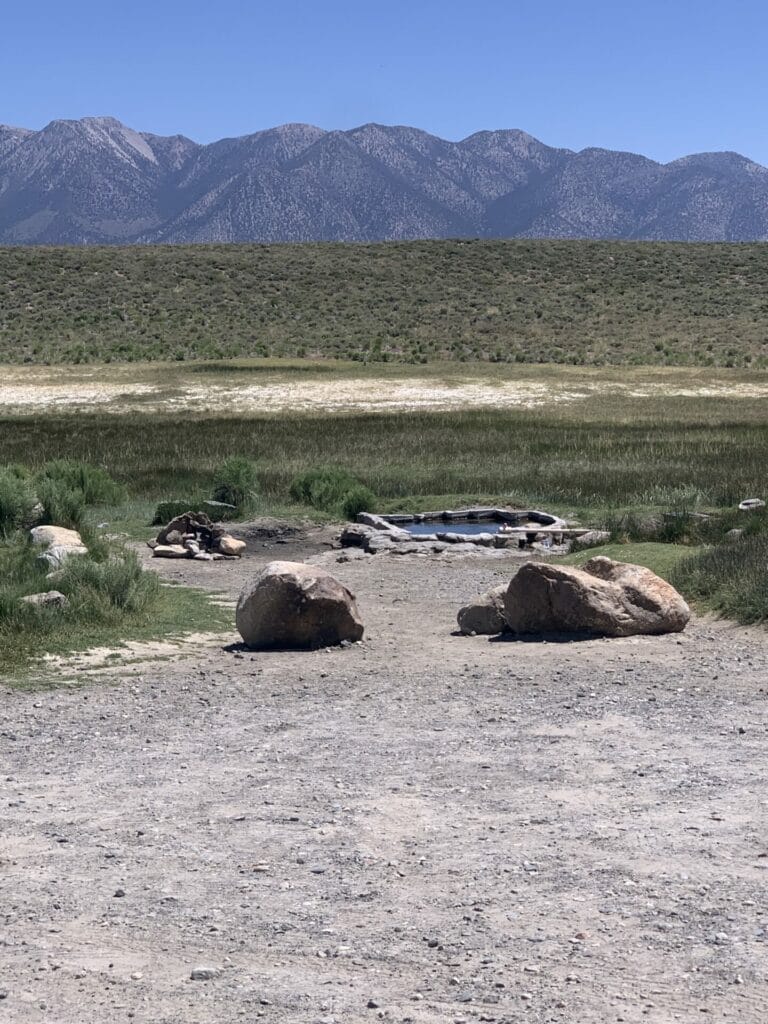 From the parking are, looking at the Shepherd Hot Springs Mammoth tub and in a distance is rugged mountain range.