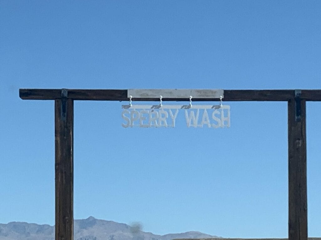 Picture of ranch style gate with Sperry Wash on it. It's the entrance to Sparry Wash from the duns side of Mojave Desert.