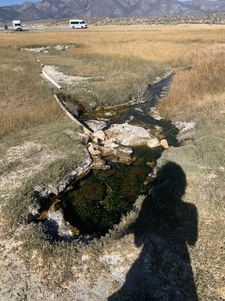 A puddle in the middle of dry grassy land...is this Lover's Tub of Mammoth Lakes?