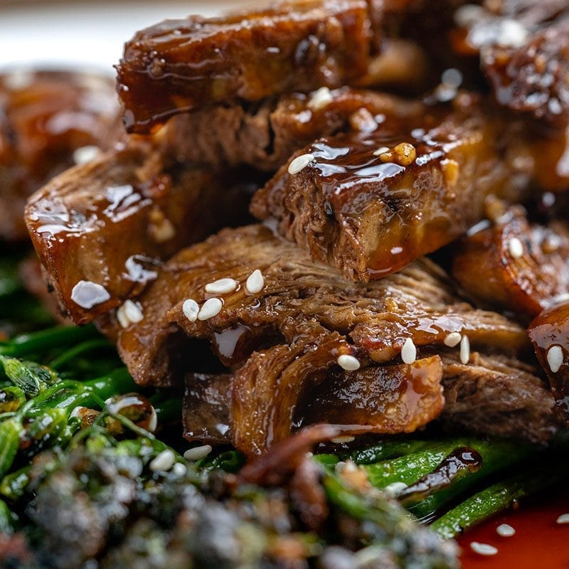 Close up of Chef Chew's Beefy Ribs over grilled veggies. Looks delicious!